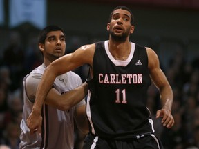 Vikas Gill #1 of the Ottawa Gee-Gees holds onto Thomas Scrubb #11 of the Carleton Ravens during a CIS OUA basketball game at Montpetit Hall in Ottawa on January 10, 2015.