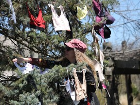 A woman hangs a bra at Ben Franklin Place where people gathered to hang bras for awareness of sexual assault prevention month, May 05, 2022.