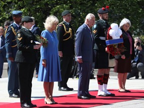 Prince Charles and Camilla, Duchess of Cornwall, lay a wreath and flowers at the National War Memorial in Ottawa on Wednesday, May 18, 2022.