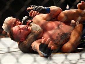 Charles Oliveira applies a hold for the submission victory against Justin Gaethje during UFC 274 at Footprint Center, May 7, 2022.