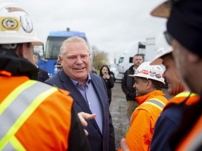 Ontario Premier Doug Ford greets workers at a construction site before speaking to the media in Brampton on Wednesday, May 4, 2022.