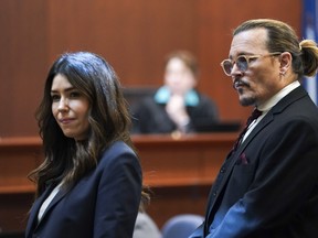 Johnny Depp stands next to his lawyer Camille Vasquez after a break in the courtroom at the Fairfax County Circuit Courthouse in Fairfax, Va., Wednesday, May 18, 2022.