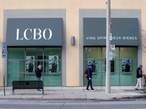 People wait outside of the LCBO to buy alcohol in Toronto, April 9, 2020.