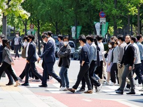 People wear masks to prevent the spread of COVID-19 as they cross a street in Seoul, South Korea, May 3, 2022.