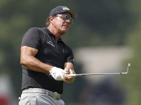 Jul 4, 2021; Detroit, Michigan, USA; Phil Mickelson hits his approach shot on the 18th hole during the final round of the Rocket Mortgage Classic golf tournament.