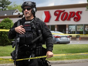 A Buffalo police officer works at the scene of a shooting at a Tops supermarket on May 17, 2022.