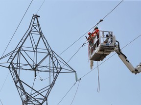 File photo/ Hydro workers Cam Fisher and Zach Pearson work on some hydro lines in Nepean.