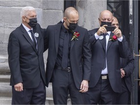 Former teammate Réjean Houle, left, consoles Martin Lafleur following the funeral for his father at Mary Queen of the World Cathedral, while former Lafleur linemate Steve Shutt records the proceedings.