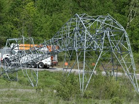 A massive hydro tower lies crumpled in half along Highway 417 near Hunt Club Road as crews continue to try to restore power.