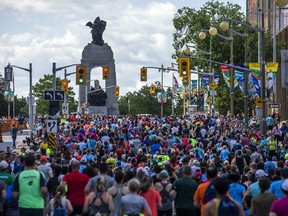 Les coureurs montent la colline sur la rue Elgin, se dirigeant vers le nord en direction du Monument commémoratif de guerre du Canada, lors de la course de 5 km samedi.