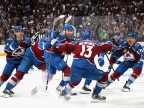 Andre Burakovsky of the Colorado Avalanche celebrates with teammates after scoring a goal against Andrei Vasilevskiy of the Tampa Bay Lightning during overtime to win Game One of the 2022 Stanley Cup Final 4-3 at Ball Arena on June 15, 2022 in Denver, Colorado.