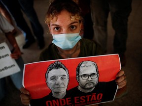 A woman holds a sign during a vigil following the disappearance of British journalist Dom Phillips and indigenous expert Bruno Pereira, who went missing while reporting in a remote and lawless part of the Amazon rainforest near the border with Peru, in front of the headquarters of Brazil's National Indian Foundation (FUNAI), in Brasilia, Brazil June 13, 2022.