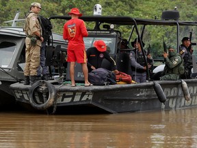 Police officers and rescue team members stand on a boat during the search operation for British journalist Dom Phillips and indigenous expert Bruno Pereira, who went missing while reporting in a remote and lawless part of the Amazon rainforest, near the border with Peru, in Atalaia do Norte, Amazonas state, Brazil, June 12, 2022.