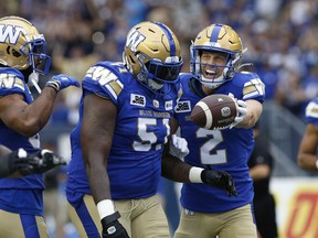 Greg Ellingson, right, celebrates his first-half touchdown on Friday night with Blue Bombers teammate Jermarcus Hardrick.