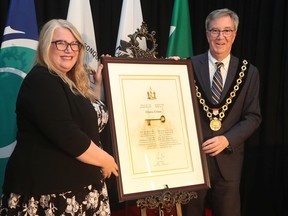 Ottawa Mayor Jim Watson presents the 'Key to the City' to Ottawa Citizen editor-in-chief Nicole MacAdam on Thursday, June 16, 2022.