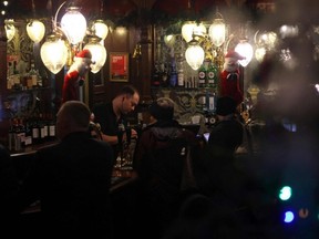 A barman pours a drink inside a dark pub in central London, Dec. 10, 2021.