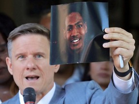 Attorney Bobby DiCello holds up a photograph of Jayland Walker, the man who was shot dead by Akron Police on June 25, as he speaks on behalf of the Walker family during a press conference at St. Ashworth Temple in Akron, Ohio, Thurs., June 30, 2022.
