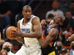 Jan 6, 2022; Phoenix, Arizona, USA; Los Angeles Clippers center Serge Ibaka (left) drives to the basket against Phoenix Suns forward Jalen Smith in the second half at Footprint Center.