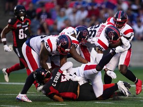 Five Montreal Alouettes players stop Ottawa Redblacks quarterback Caleb Evans (5) during first-half CFL action in Ottawa on Thursday, July 21, 2022.