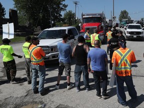 Construction workers from LiUNA Local 527 walk the picket line at Moodie Drive in Ottawa on Tuesday.