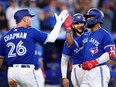 Blue Jays' Matt Chapman, left, and Bo Bichette, centre, celebrate a three-run home run by Teoscar Hernandez, right, in the sixth inning against the Cubs at Rogers Centre in Toronto, Tuesday, Aug. 30, 2022.