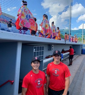 Ottawa Titans receiver Mitsuki Fukuda (left) and pitcher Kenny Williams pose in front of a group of dancers during Japan Night at Ottawa Stadium.