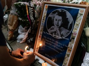 Mourners place candles next to flower tributes for Queen Elizabeth II outside the British Consulate as the world reacts to the passing Of Queen Elizabeth II on Sept. 19, 2022 in Hong Kong, China.