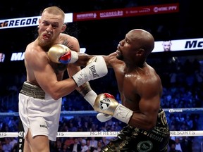 Floyd Mayweather Jr. throws a punch at Conor McGregor during their super welterweight boxing match on August 26, 2017 at T-Mobile Arena in Las Vegas, Nevada.