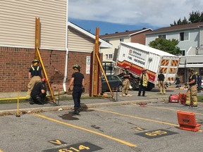 Ottawa Fire Services structural collapse technicians work on a three-storey townhouse that was struck by a vehicle on Friday afternoon.