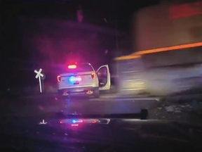 Screen shot of police car parked on tracks about to get hit by a train.