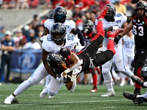Redblacks running back Devonte Williams (31) gets knocked off his feet by Argos linebacker as he runs with the ball in the first half of Saturday's game.