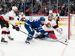 Maple Leafs winger Mitchell Marner tries to control the puck in front of Senators netminder Cam Talbot during the first period.