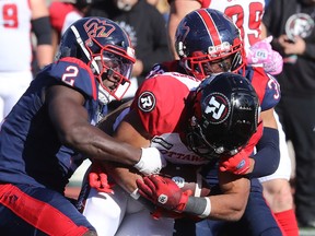 Montreal Alouettes's Micah Awe (2) and Montreal Alouettes's Wesley Sutton (37) bring down Ottawa Redblacks's Jackson Bennett (22) during second half CFL action in Montreal on Monday, Oct. 10, 2022.