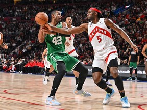Al Horford of the Boston Celtics protects the ball from Precious Achiuwa of the Toronto Raptors.