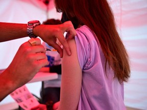 A youth receives a  vaccine against Covid-19.