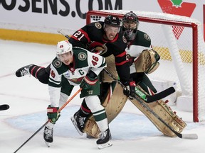 Minnesota Wild defenceman Jared Spurgeon keeps his eye on the puck as he ties up Ottawa Senators right wing Mathieu Joseph in front of goaltender Marc-Andre Fleury during second period NHL action, Thursday, Oct. 27, 2022 in Ottawa.