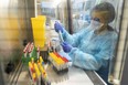 Laboratory operator handles positive COVID-19 samples to be sequenced in the virology laboratory of the AP-HP Henri Mondor Hospital in Creteil, on the outskirt of Paris on Dec. 7, 2021.