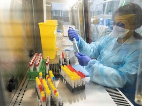 Laboratory operator handles positive COVID-19 samples to be sequenced in the virology laboratory of the AP-HP Henri Mondor Hospital in Creteil, on the outskirt of Paris on Dec. 7, 2021.