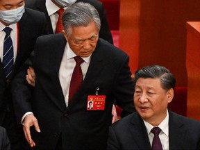 China's President Xi Jinping (right) talks to former president Hu Jintao as he is assisted to leave from the closing ceremony of the 20th Chinese Communist Party's Congress at the Great Hall of the People in Beijing, Saturday, Oct. 22, 2022.