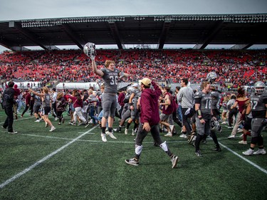 Gee-Gees player Charles Tittley (36) celebrates with uOttawa supporters on the field.