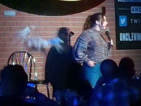 A beer can thrown by a heckler in the audience narrowly misses comic Ariel Elias.