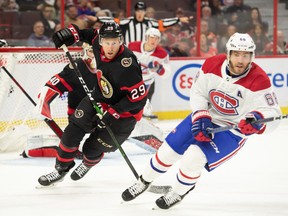 Le défenseur des Sénateurs d'Ottawa Dillon Heatherington (29 ans) et l'ailier gauche des Canadiens de Montréal Mike Hoffman (68 ans) poursuivent la rondelle en première période au Centre Canadian Tire.