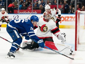 Ottawa Senators goaltender Cam Talbot battles for the puck with Toronto Maple Leafs right wing Mitchell Marner during the first period at Scotiabank Arena, Sept. 24, 2022.