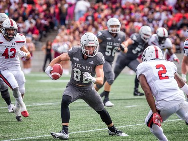 Gee Gees receiver Nicholas Gendron battles past Ravens defenders on his way to a game-high total of 211 yards on eight catches.