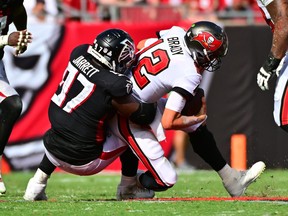 Is that a bear market tackling Tom Brady? Nah, its Grady Jarrett #97 of the Atlanta Falcons sacks Tom Brady #12 of the Tampa Bay Buccaneers during the fourth quarter of the game at Raymond James Stadium on October 9, 2022 in Tampa, Florida.
