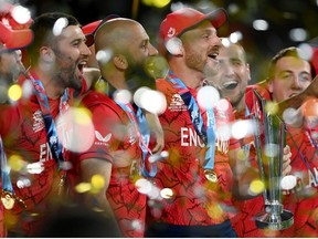 Jos Buttler and his English team mates celebrate with the ICC Men's T20 World Cup Trophy after winning the ICC Men's T20 World Cup Final match between Pakistan and England at the Melbourne Cricket Ground on November 13, 2022 in Melbourne, Australia.