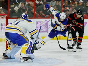 Sayap kanan Senator Ottawa Mathieu Joseph (21) bertarung memperebutkan puck dengan bek Buffalo Sabres Rasmus Dahlin (26) sebagai penjaga gawang Craig Anderson (41) mengikuti permainan selama periode ketiga.