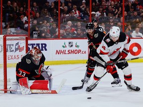 Ottawa Senators defenceman Nick Holden (5) and New Jersey Devils right wing Nathan Bastian (14) battle for a loose puck in front of goaltender Cam Talbot (33) during second period NHL action at the Canadian Tire Centre on Saturday, Nov. 19, 2022.