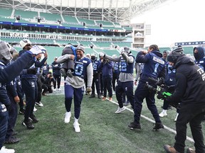 Argonauts linebacker Henoc Muamba picks up head coach Ryan Dinwiddie's son 3-year-old son Lansen on the field during a team walkthrough as they get ready to take on the Winnipeg Blue Bombers at the 109th Grey Cup at Mosaic Stadium.