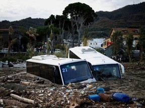 Damaged buses lie amongst debris following a landslide on the Italian holiday island of Ischia, Sunday, Nov. 27, 2022.
